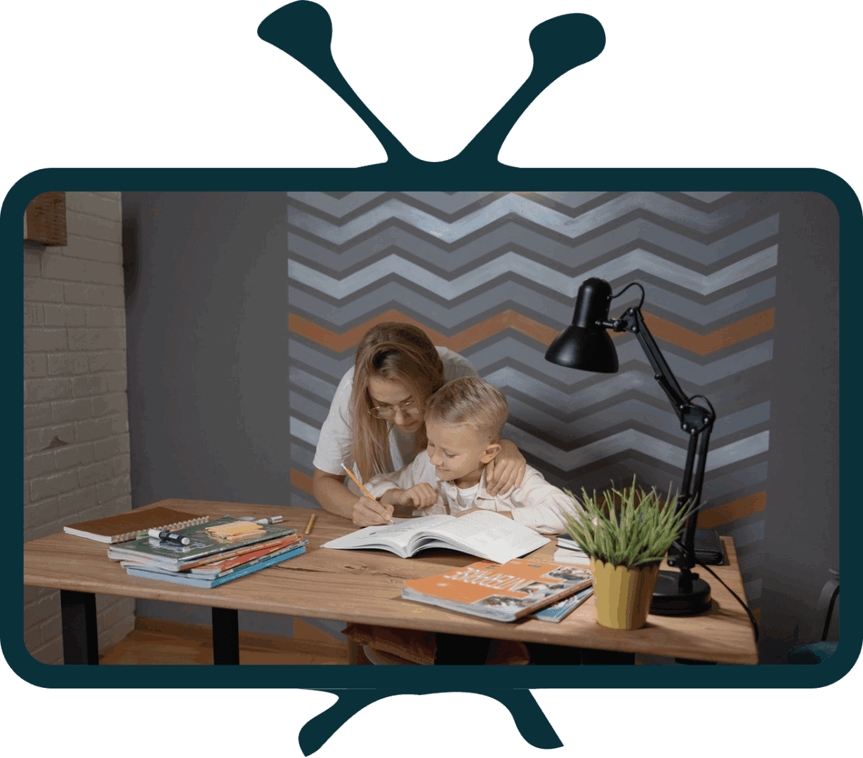 Child and adult studying together at desk.