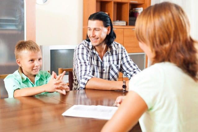 Family discussing around a wooden table.