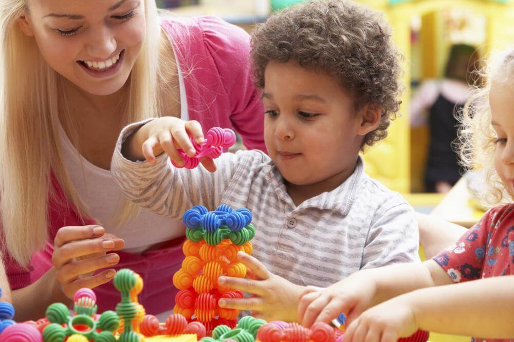 Children building with colorful plastic toys.